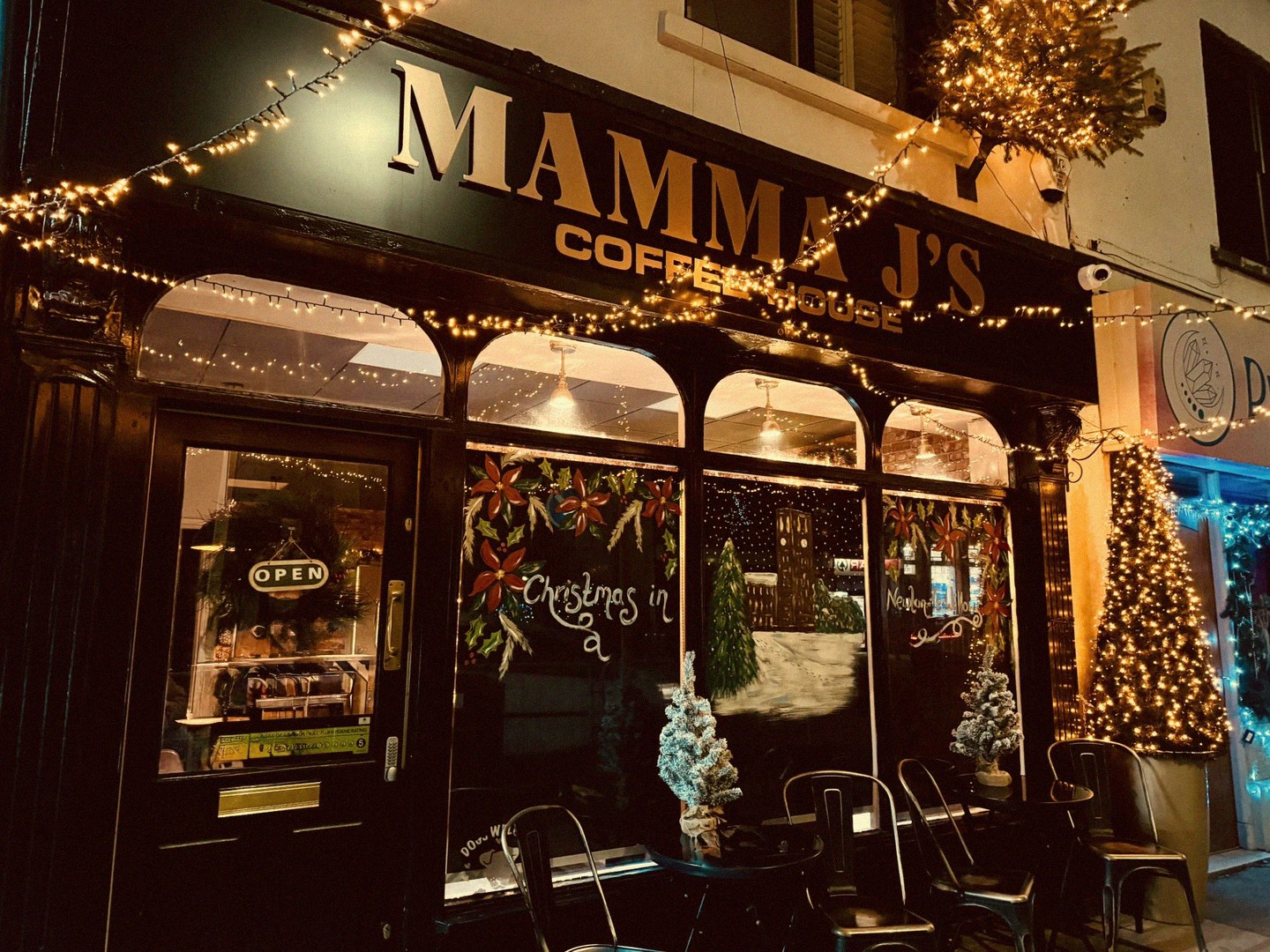 Mamma J's Coffee House exterior at night with fairy lights, Christmas decorations and outdoor seating