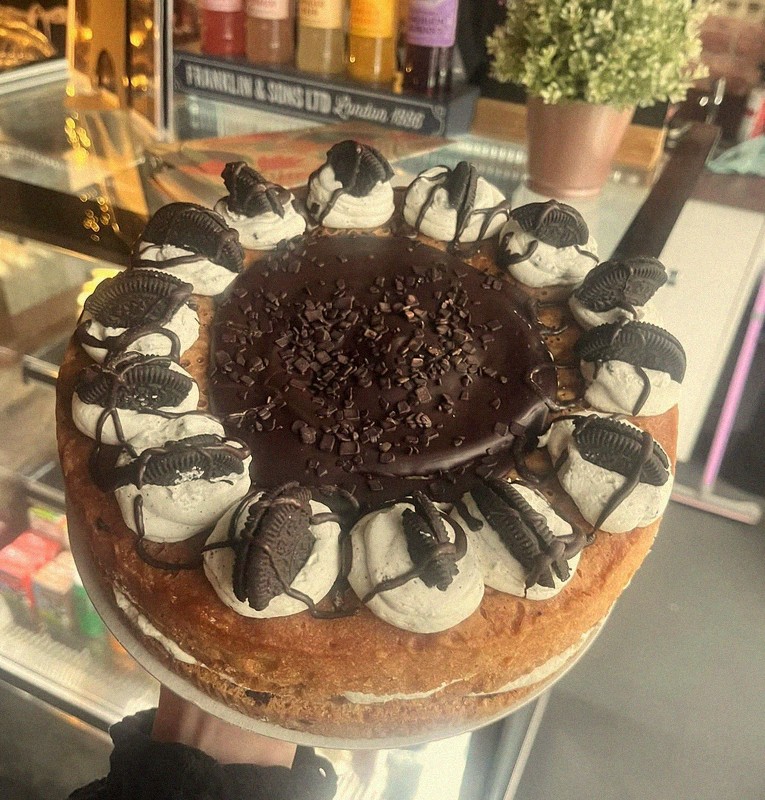 Stunning Oreo cookie cake with chocolate ganache and cream swirls on display at Mamma J's