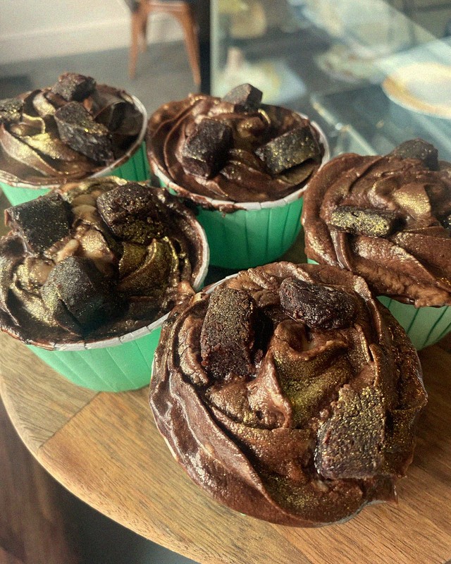 Rich chocolate cupcakes with gold-dusted frosting and Oreo pieces, handmade at Mamma J's